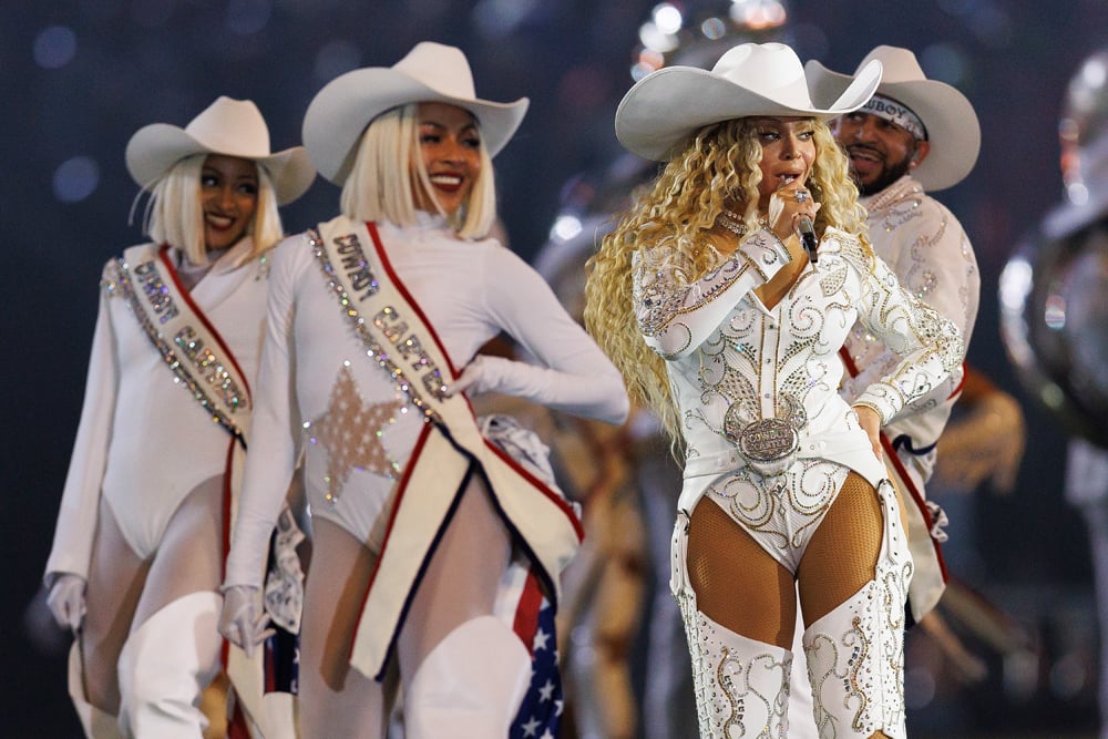 Attendue en concert à Paris en 2025, la chanteuse Beyoncé prend la pose sur scène dans une tenue de cowboy blanche.
